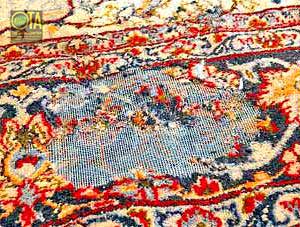 Ausgefressene Stellen im Teppichflor von Motten in einem antiken Teppich